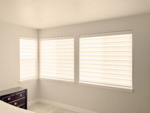 Zebra shades covering large windows in a modern, bright living room for stylish light control.