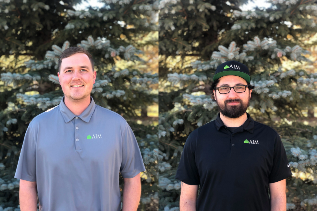Two AIM team members in Denver, wearing branded shirts outdoors.