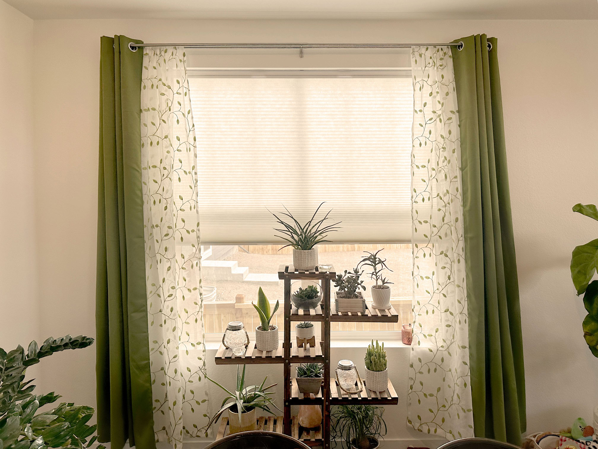 Elegant green and patterned curtains with sheer blinds in a modern living room.