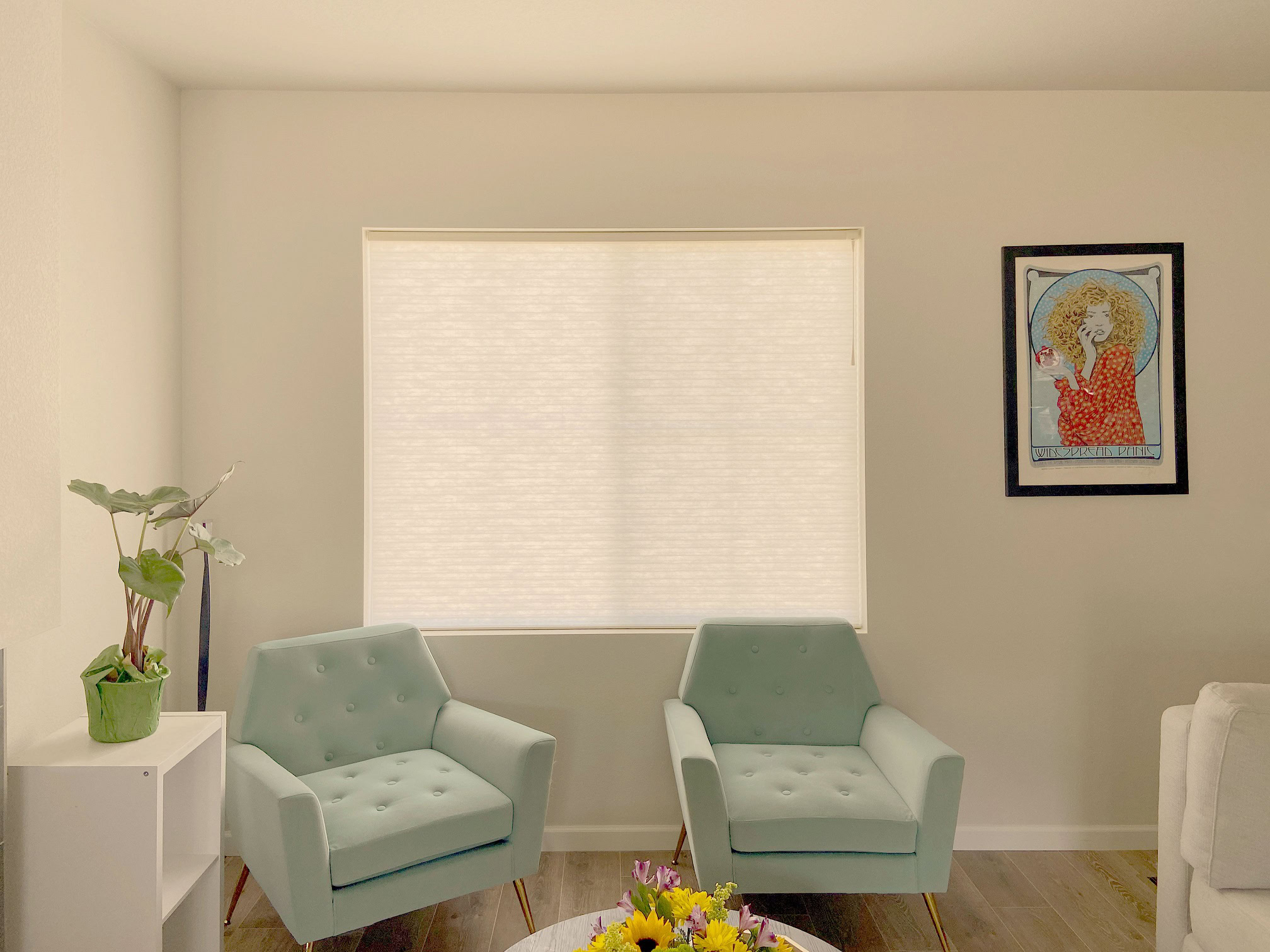 AIM window treatments in a cozy Centennial living room with two light blue armchairs and wall art.