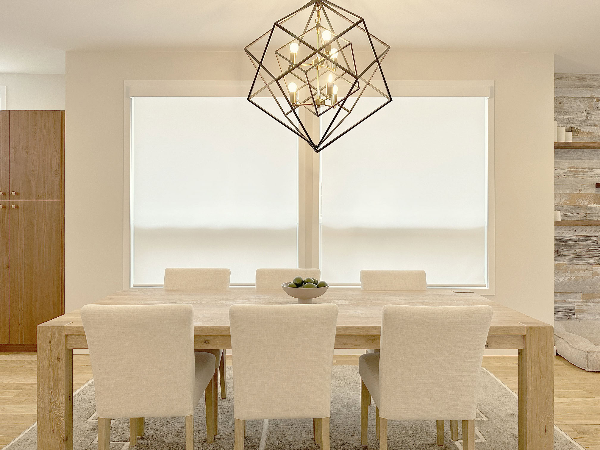 Elegant dining area featuring a contemporary geometric chandelier and neutral-toned furniture.