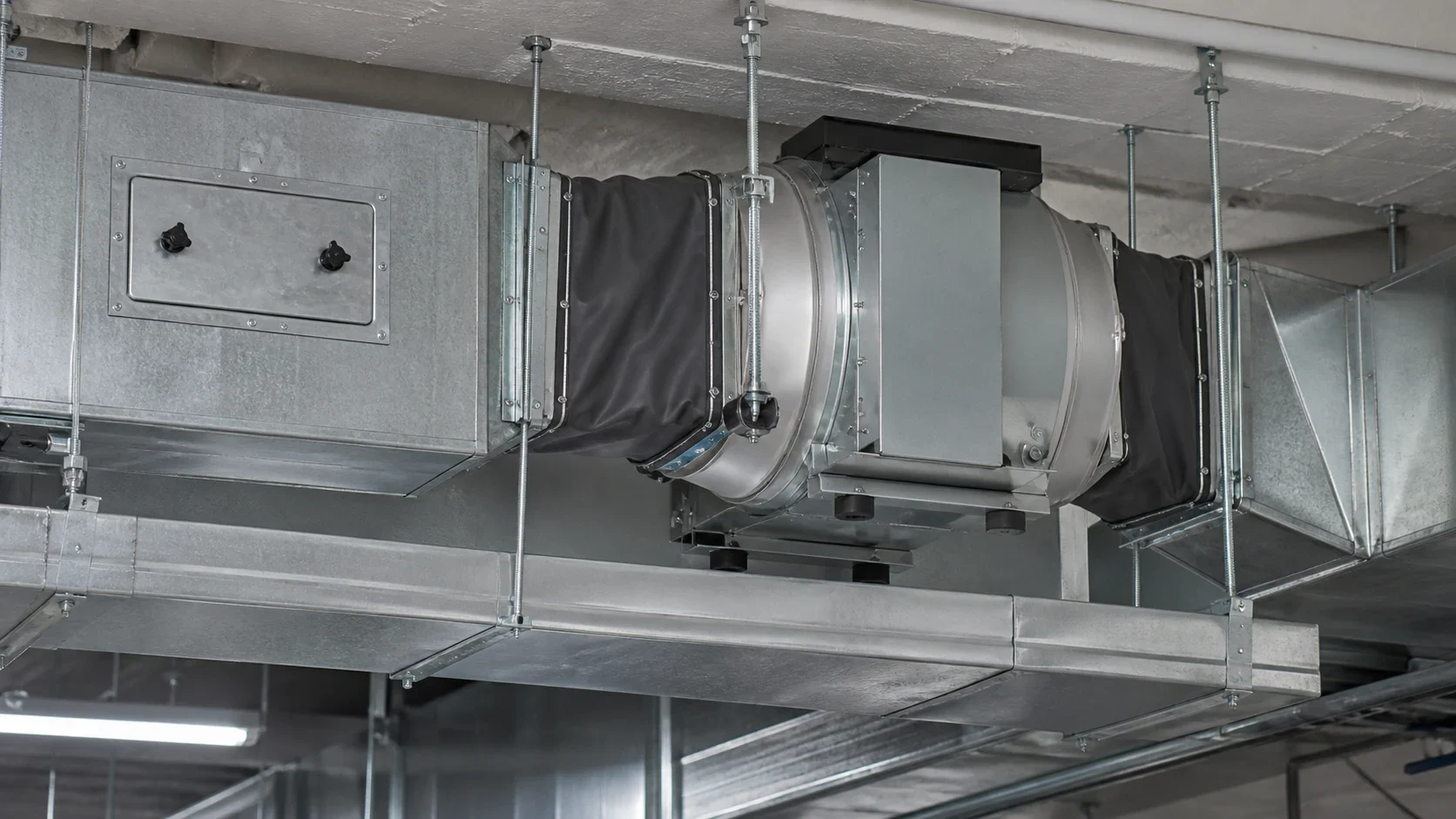 Ventilateur de gaine, manchettes souples et trappe de visite d’un réseau d’extraction de cuisine professionnelle.
