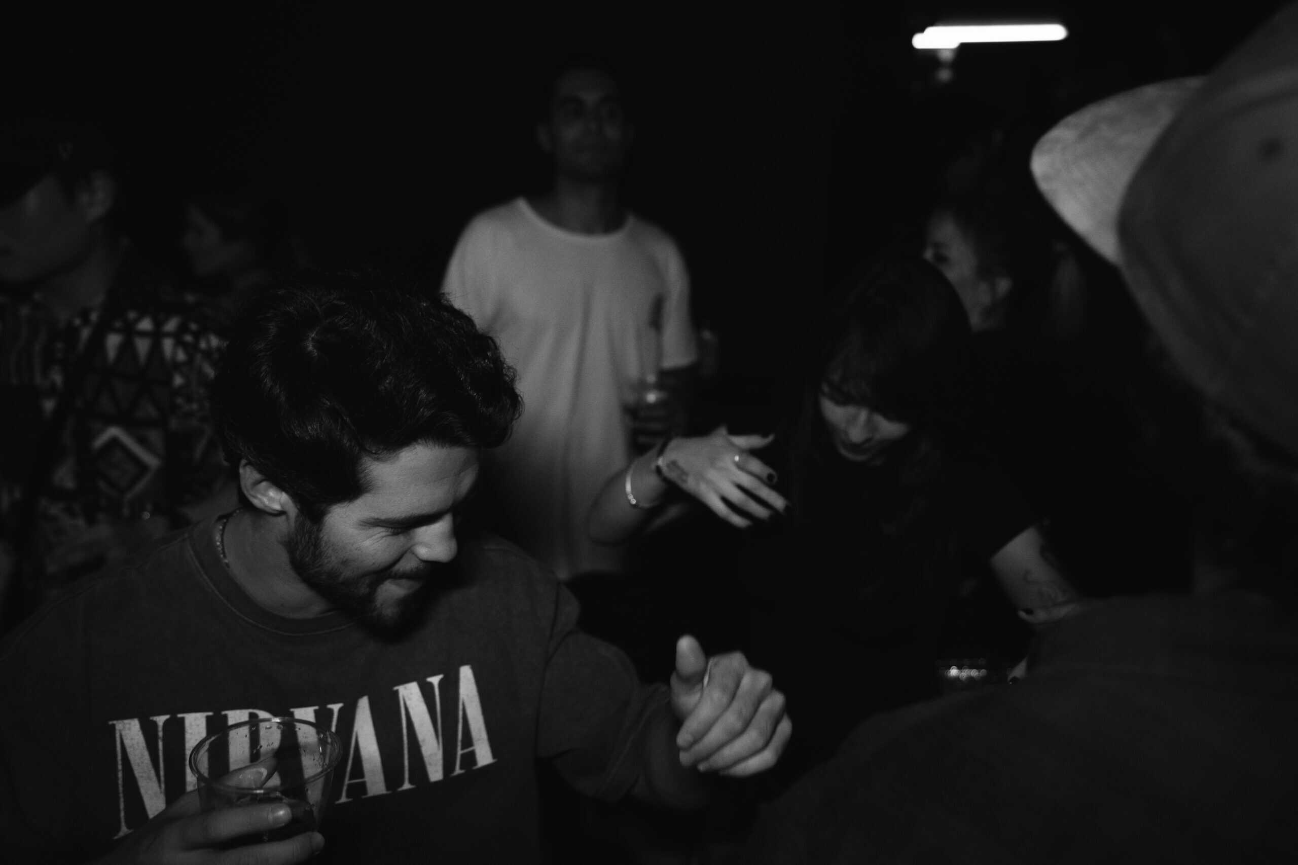 Jongeren genieten van nachtleven in Akhnaton Amsterdam, dansen en socialiseren in een gezellige sfee.