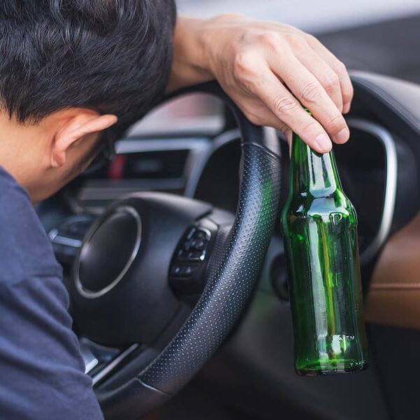 driving an automobile while intoxicated while carrying a bottle of beer. notion of not drinking and driving. driving while intoxicated DUI, driving after drinking.