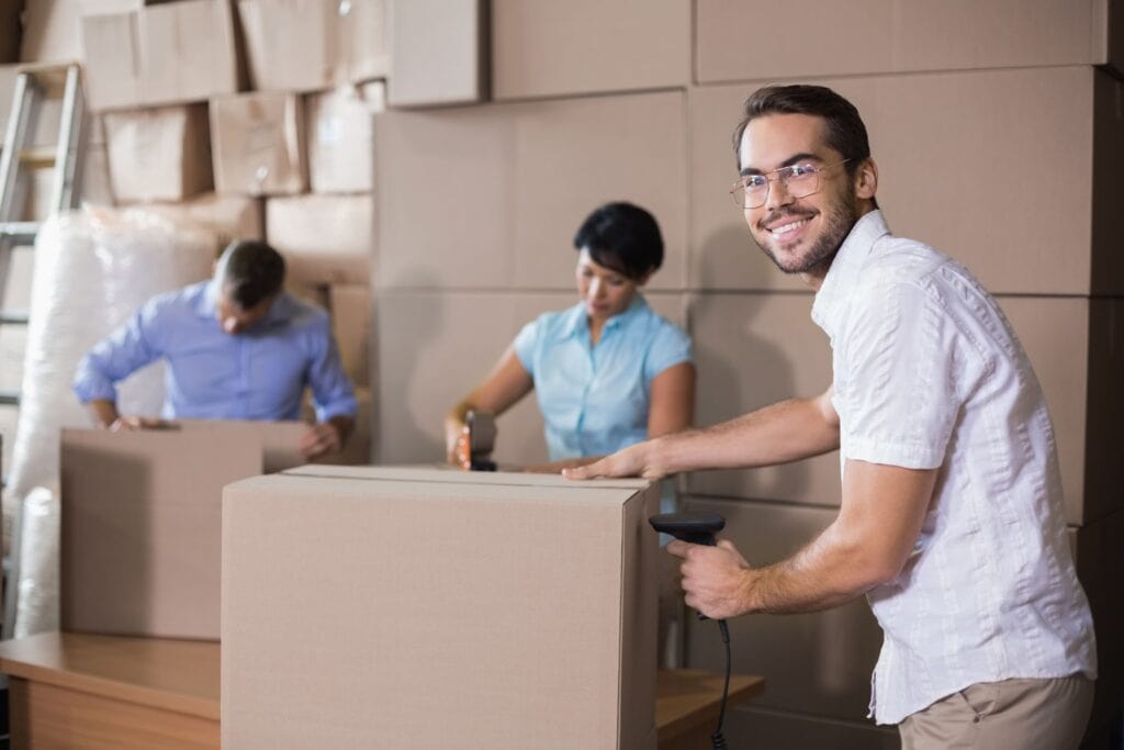 Happy mover packing boxes in a warehouse for a move in Banff.