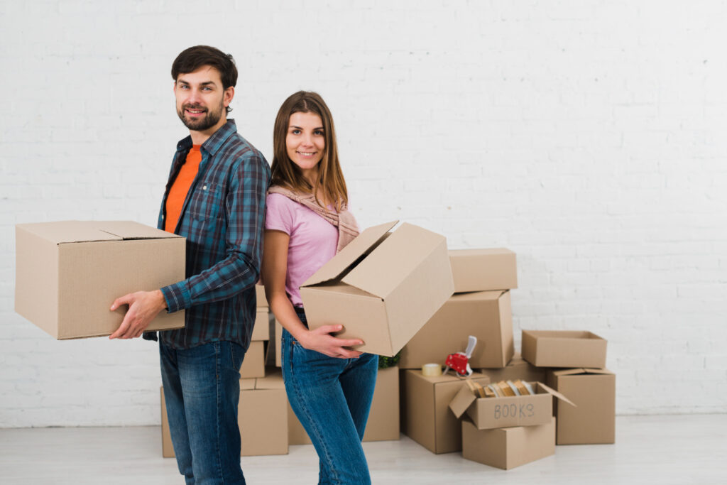 Happy movers holding boxes during a move in Beaumont.