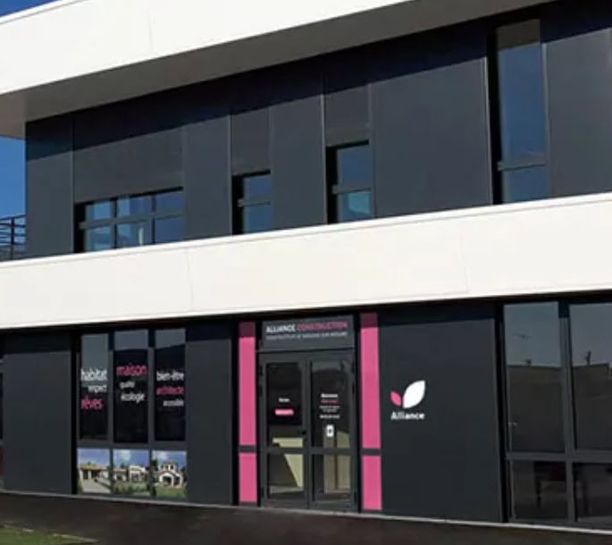 agence-lesherbiersFaçade d’une agence Alliance Group spécialisée dans la promotion, la construction, la rénovation et l’aménagement, avec des vitrines mettant en avant leurs réalisations et services, située dans un environnement urbain avec une entrée accueillante.