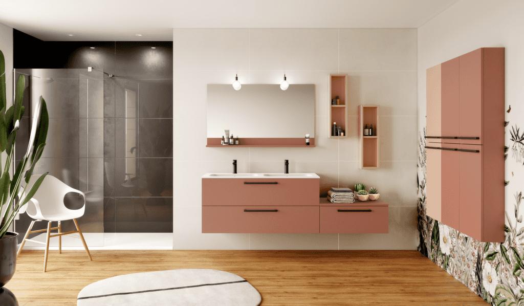 Cette salle de bain au style élégant se distingue par sa palette douce en pêche de vigne et ses lignes épurées. Le meuble double vasque suspendu, associé à des rangements muraux assortis, optimise l'espace tout en apportant une esthétique contemporaine. Le mur floral à motifs délicats contraste harmonieusement avec les finitions mates et les touches noires des poignées et robinetteries, ajoutant une touche moderne. Le parquet en bois clair réchauffe l'ambiance, tandis que la douche vitrée et les accessoires minimalistes complètent cette atmosphère apaisante et sophistiquée.