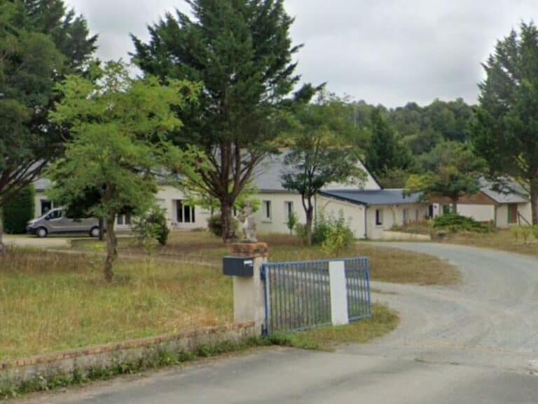 Vue extérieure d'une maison rénovée avec aménagement paysager et entrée refaite.