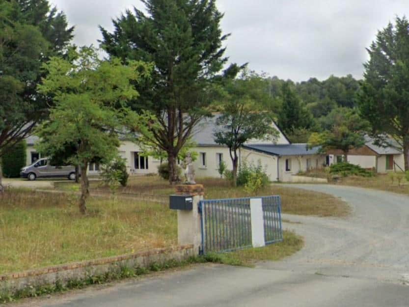 Vue extérieure d'une maison rénovée avec aménagement paysager et entrée refaite.