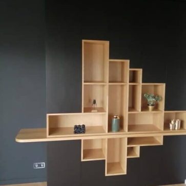 Bibliothèque murale design en bois clair avec fond noir mat, combinant des étagères ouvertes et une tablette intégrée. Un meuble moderne et structuré qui apporte chaleur et contraste dans un intérieur contemporain.