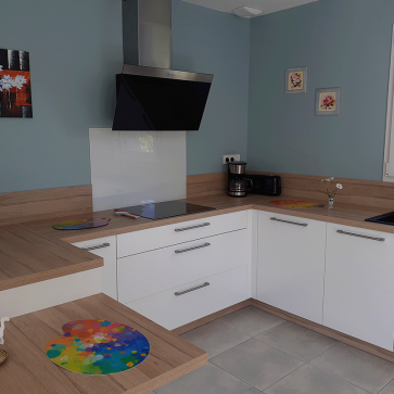 Cuisine moderne avec implantation en U, plan de travail en bois clair et appareils intégrés.
