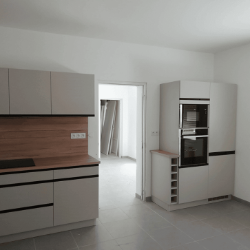 Cuisine moderne en U avec appareils intégrés et plan de travail en bois.