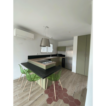 Cuisine moderne en U avec plan de travail en bois et bar avec trois chaises.