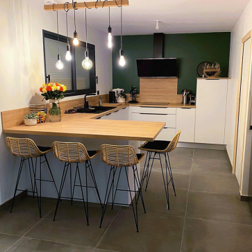 Cuisine moderne avec îlot central et éclairage suspendu, design élégant.