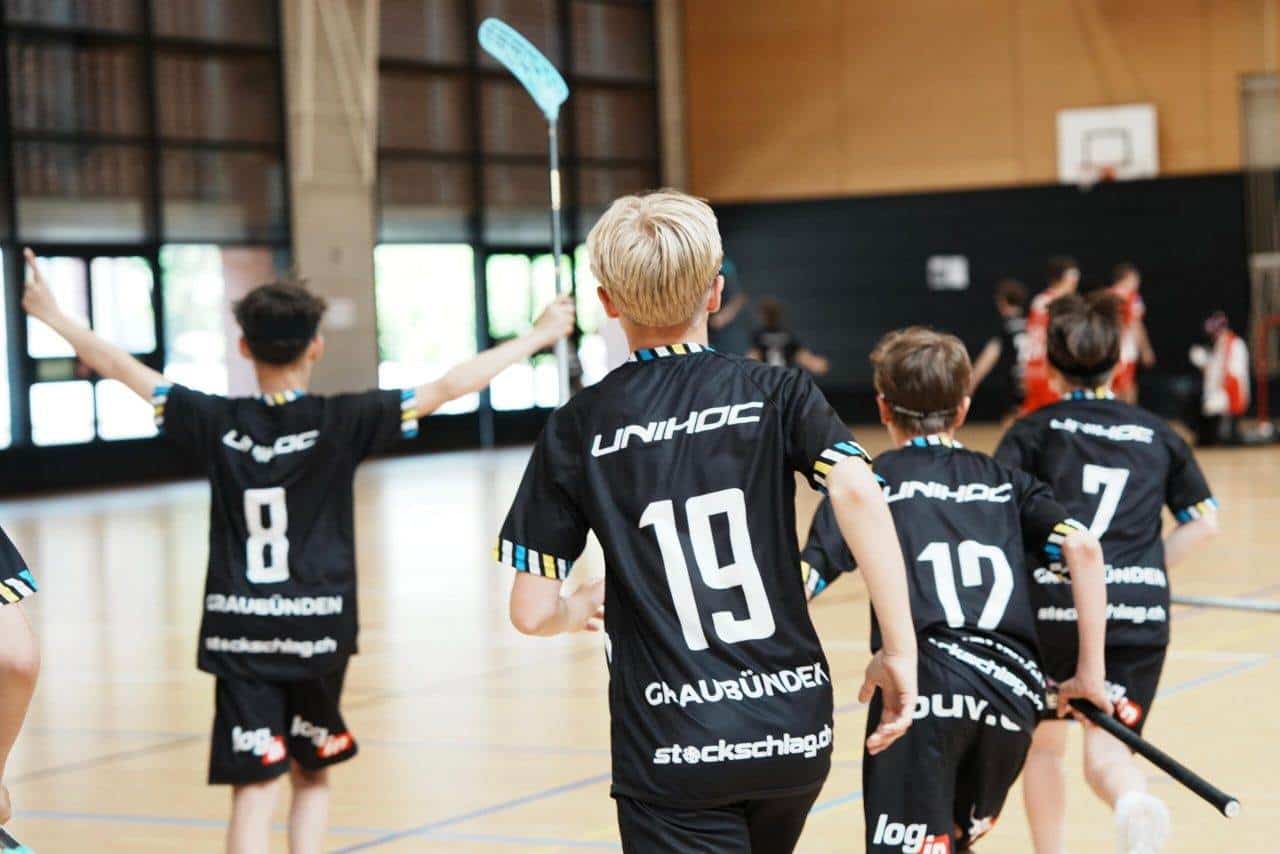 Rode Handball-Jugendmannschaft im Teamtraining, Jüngste Spieler beim Handballspiel, Hallensport, Teambuilding, UHC Alligator Malans, Sport für Kinder und Jugendliche.