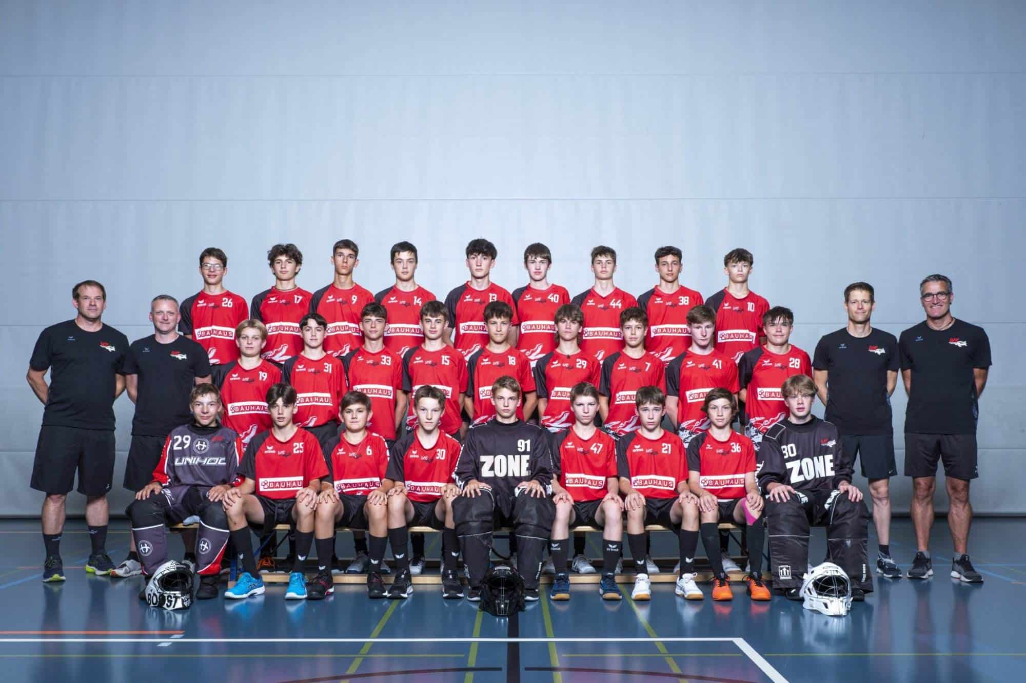 Jugendhandballteam UHC Alligator Malans in roten Trikots, Trainer und Betreuer, Mannschaftsfoto, Hallenbild, Sportteam.