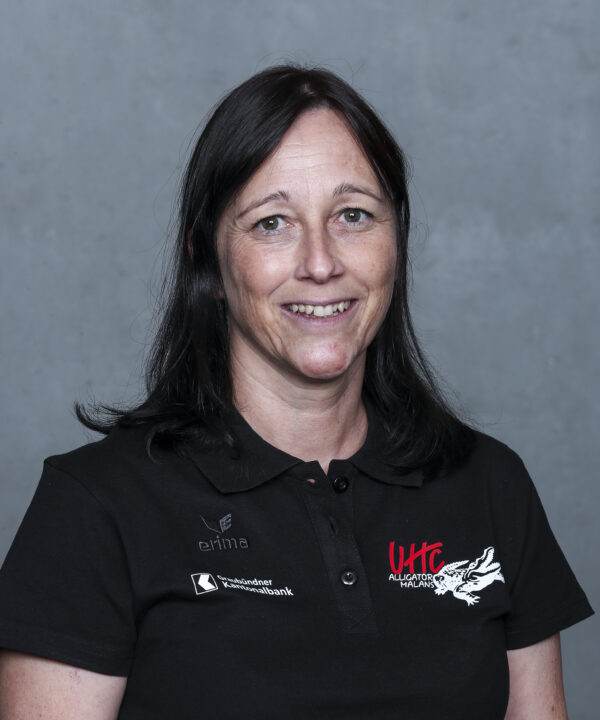 UHC Alligator Malans Mitarbeiterin in schwarzem Polo-Shirt mit Logo, Lächelnd, Vorderansicht, professionell.