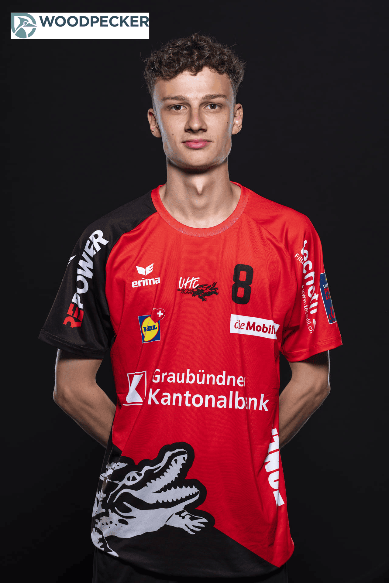 UHC Alligator Malans Volleyballspieler in Vereinstrikot mit Logo und Sponsoren vor schwarzem Hintergrund.