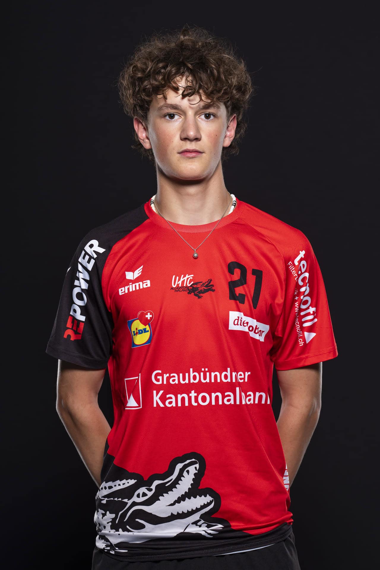 Junge Volleyballspielerin der UHC Alligator Malans in rotem Trikot vor schwarzem Hintergrund.