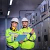 Técnicos revisando paneles eléctricos en planta industrial con equipo de protección.