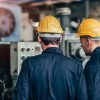 Personal técnico revisando maquinaria industrial en planta de producción.