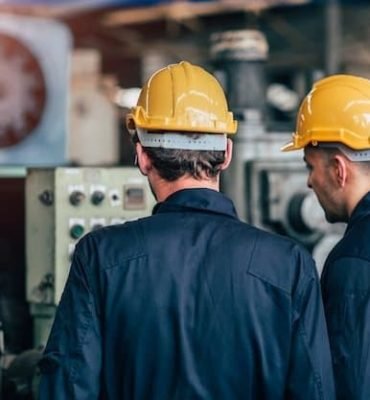 Personal técnico revisando maquinaria industrial en planta de producción.