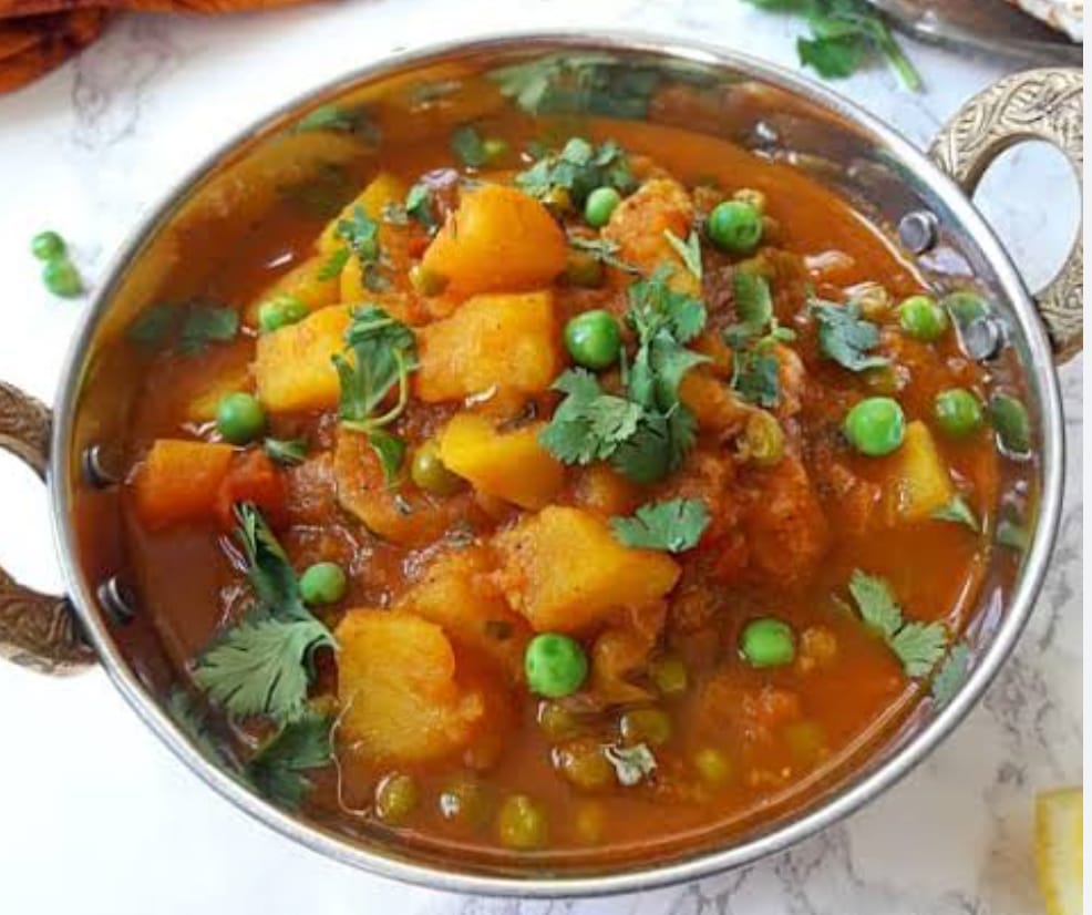 Aloo Matar curry with potatoes, green peas, and spices served with naan