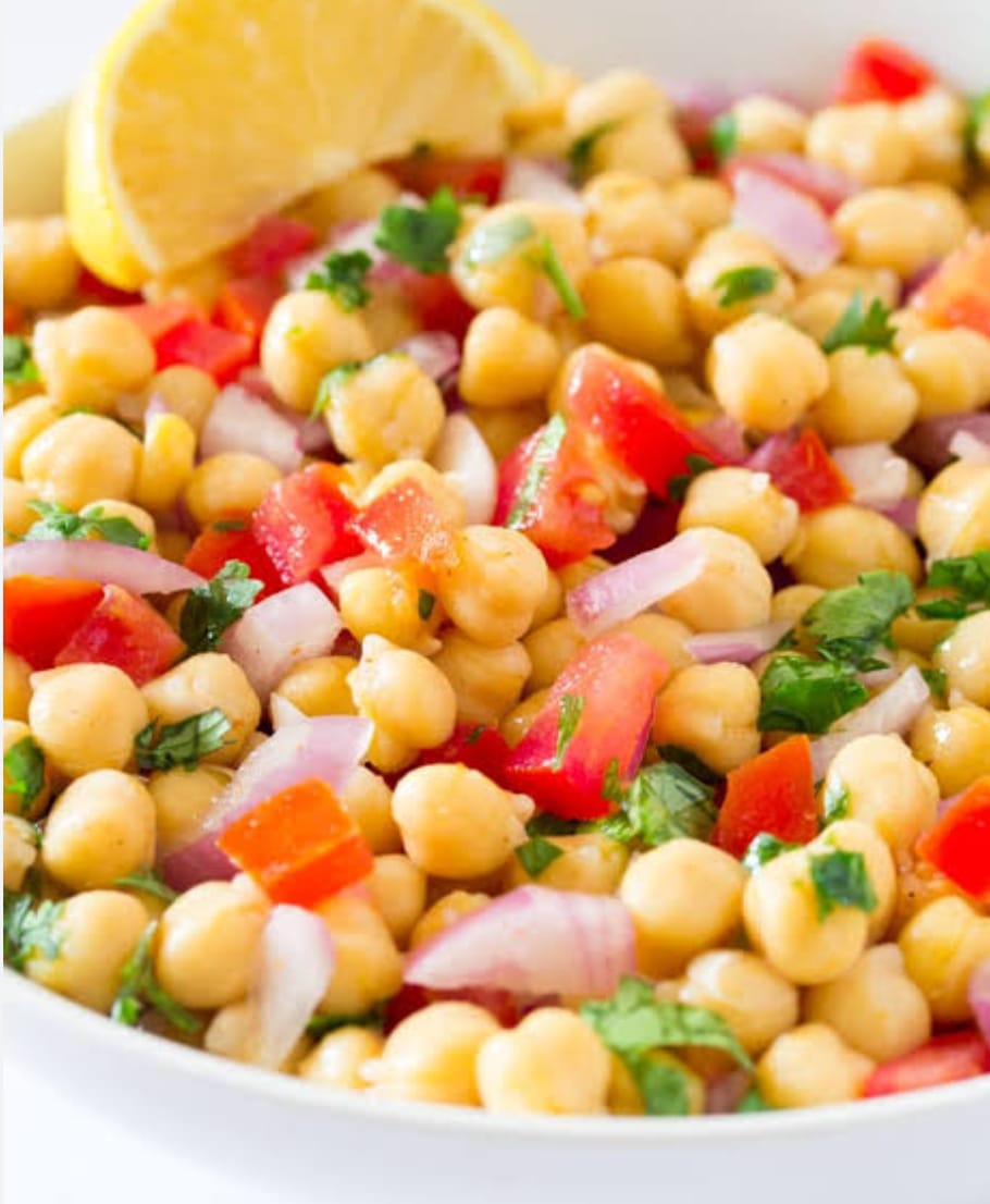Chana Chaat with chickpeas, onions, tomatoes, chutneys, and masala served in a bowl