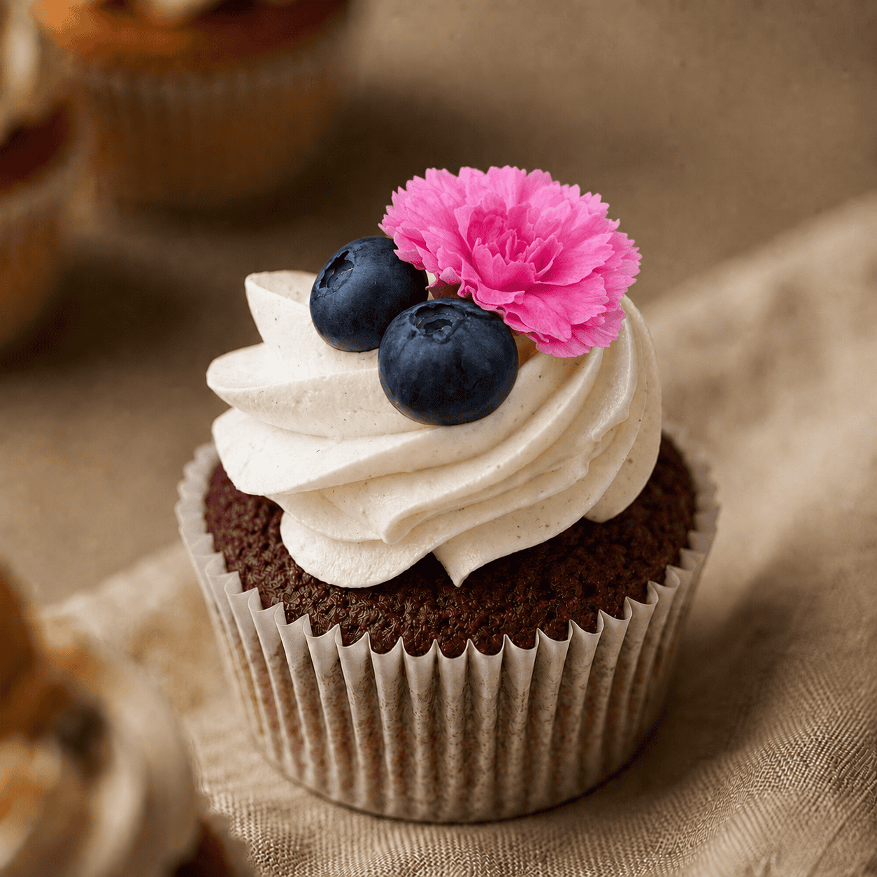 Bruiloft cupcake met roze bloem en blauwe bessen