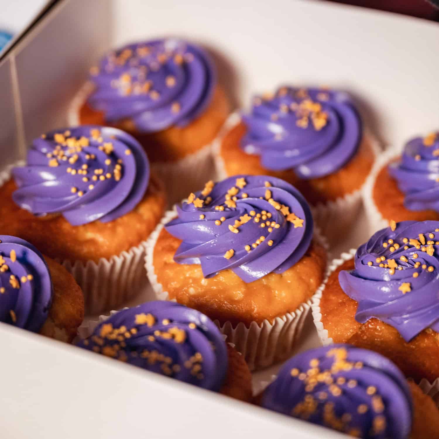 Paarse cupcakes met sprinkles vervoeren.