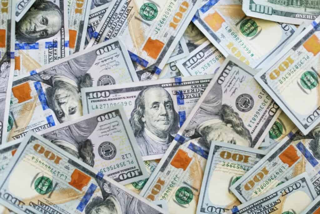 Pile of US hundred dollar bills. Earn cash from home.