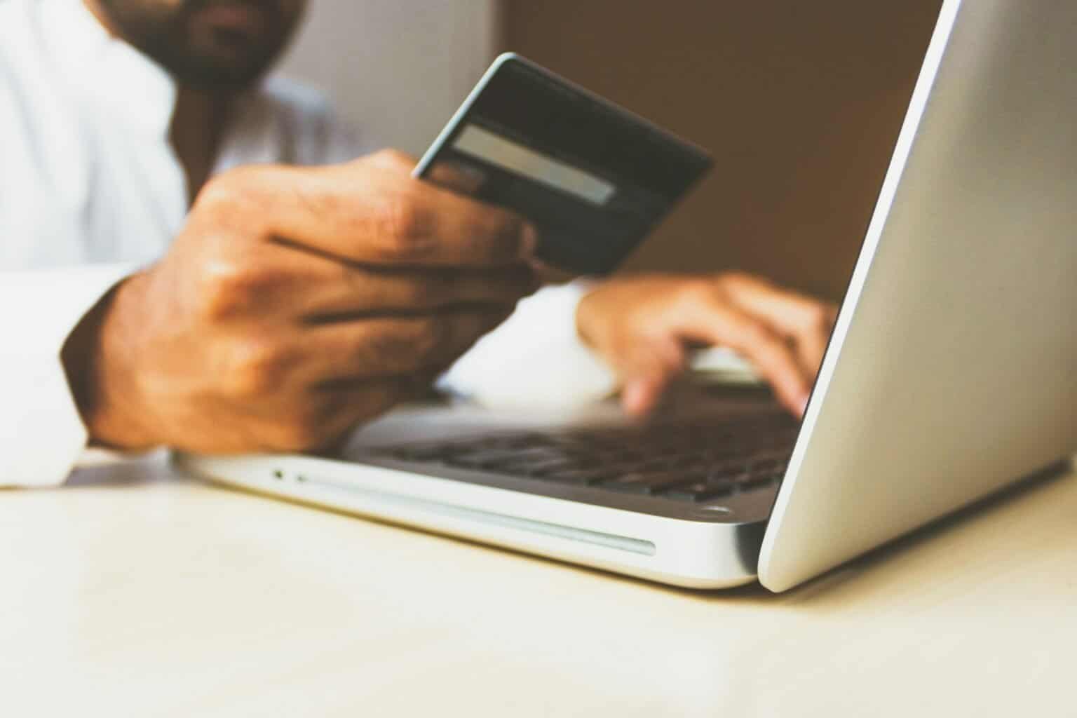 Man using credit card for online shopping on laptop