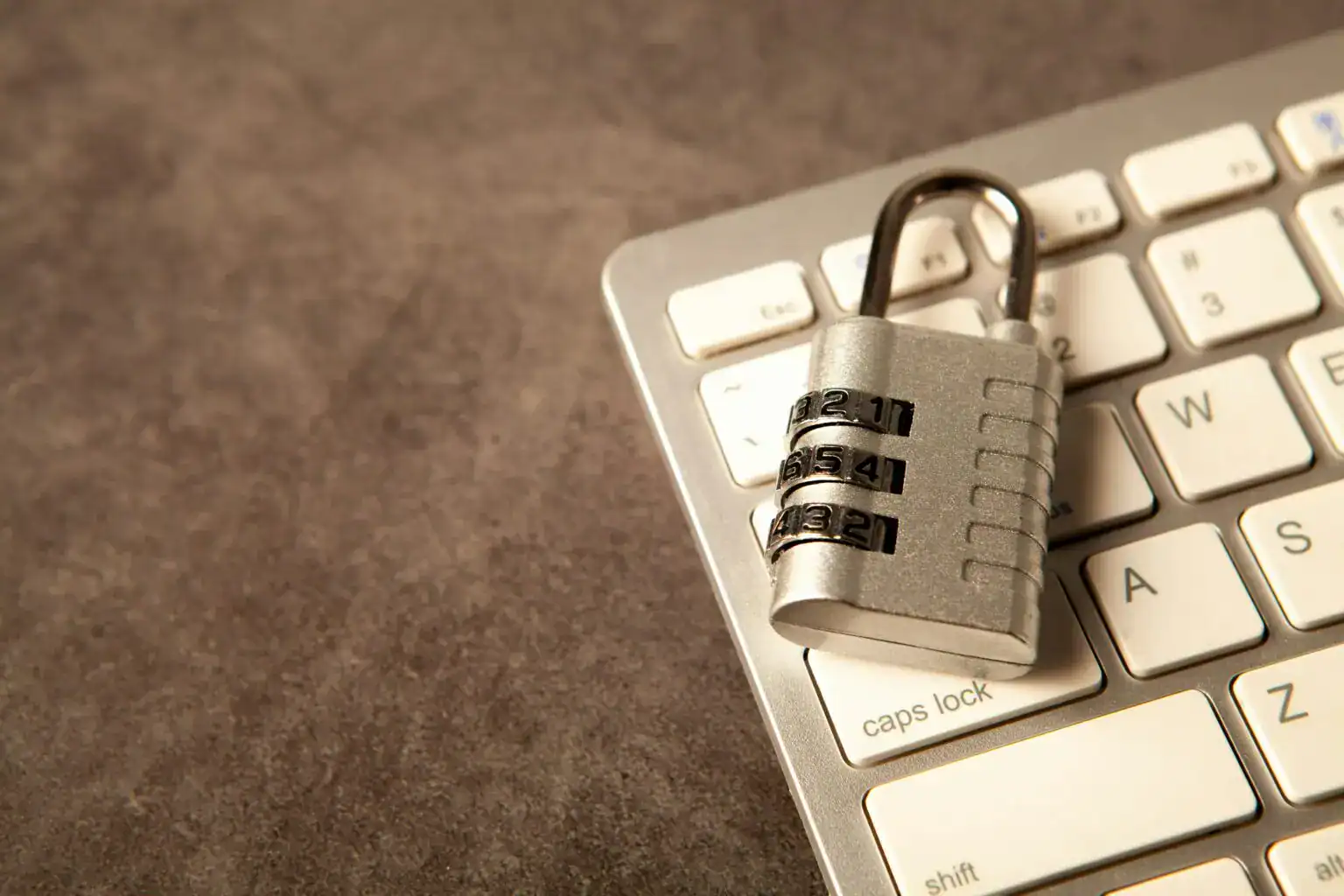 Combination lock on a keyboard, symbolizing mobile app security measures.