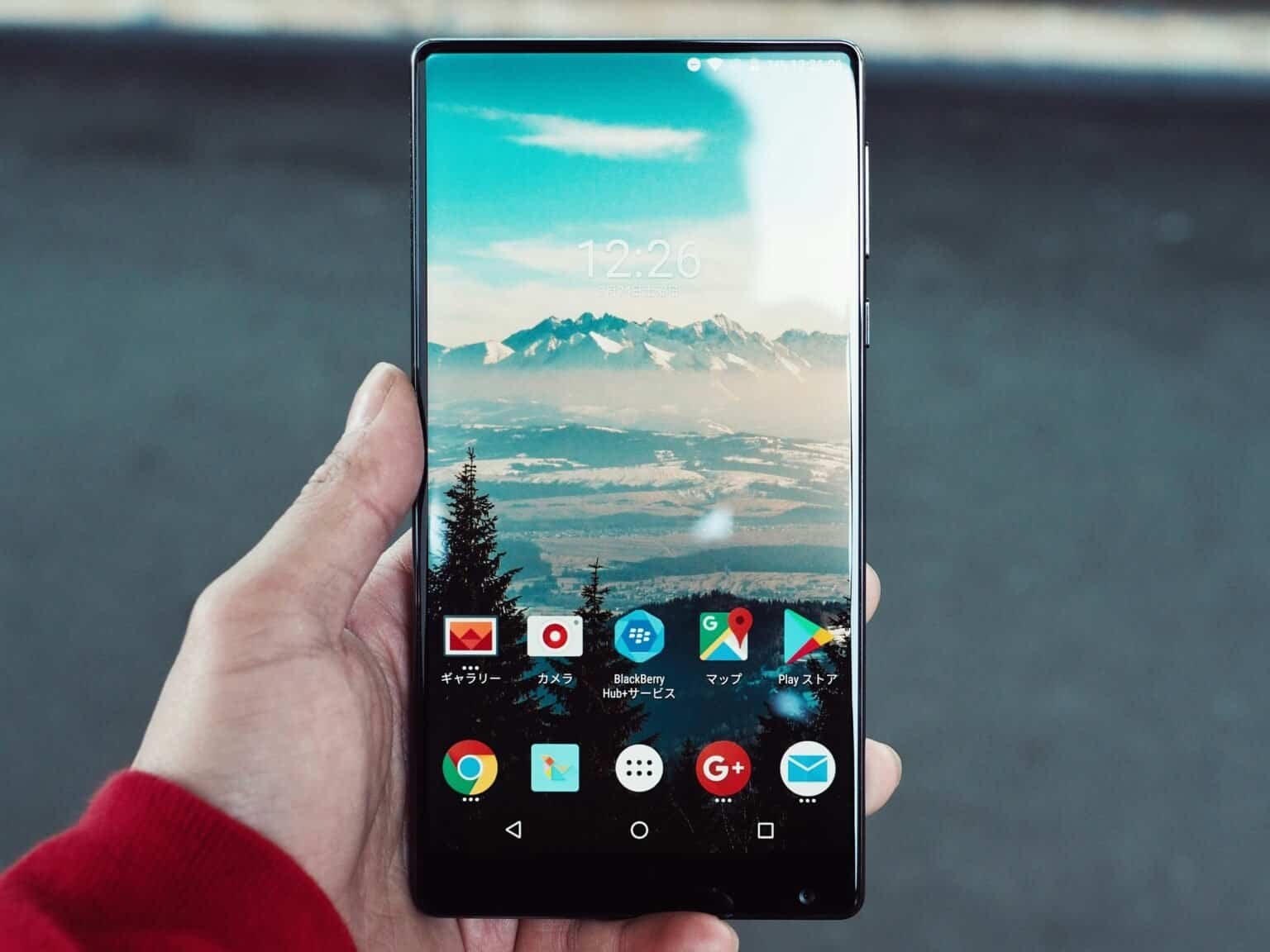 BlackBerry KEYone smartphone displaying a mountain landscape wallpaper and app icons