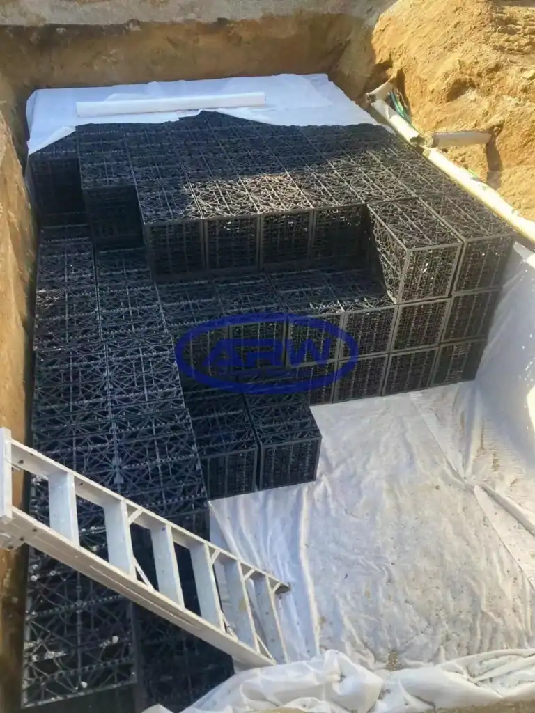 ANZ residential OSD system—geocellular crates laid on white nonwoven geotextile; side pipes connect the bed for attenuation and infiltration.