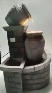 Wall-mounted stone fountain spout for small garden spaces
