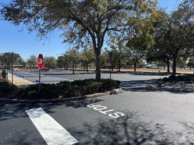 Completed commercial parking lot with underground stormwater detention system installed beneath showing no visible surface impact