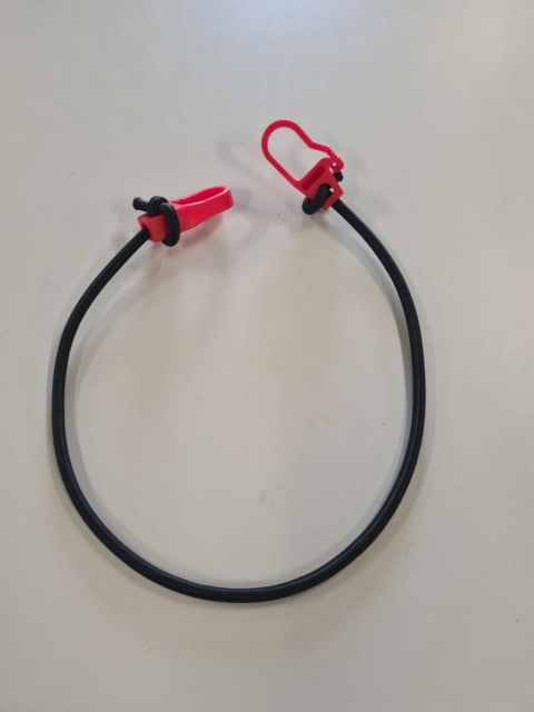 Elastische koord met rode klemmen op tafel
