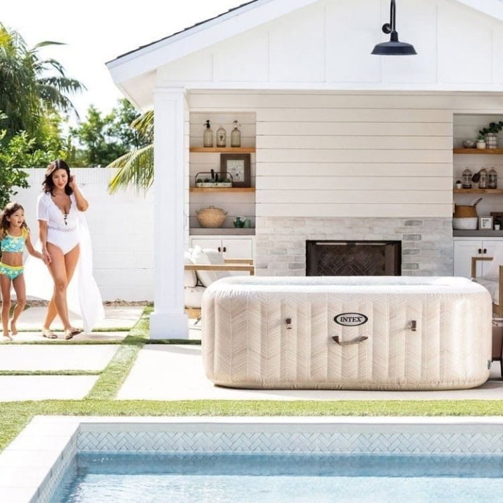 Gezin naast zwembad met opblaasbare jacuzzi