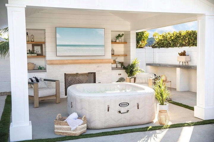 Buitenruimte met opblaasbare hot tub en bank.