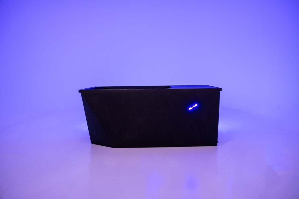 Zwart rechthoekig object met blauw licht op paarse achtergrond.