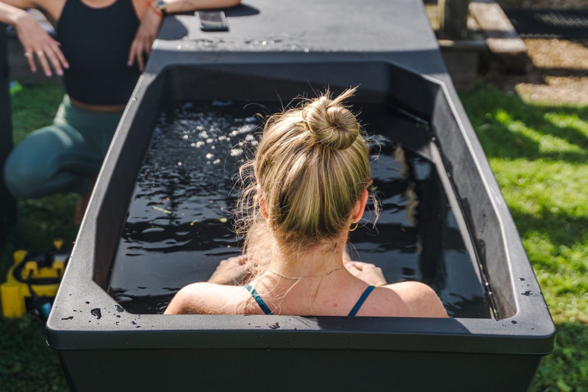 Vrouw in ijsbad geniet van koude therapie buiten.