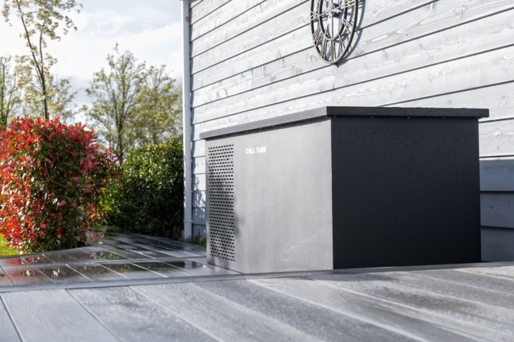 Zwart apparaat naast houten schuur in tuin