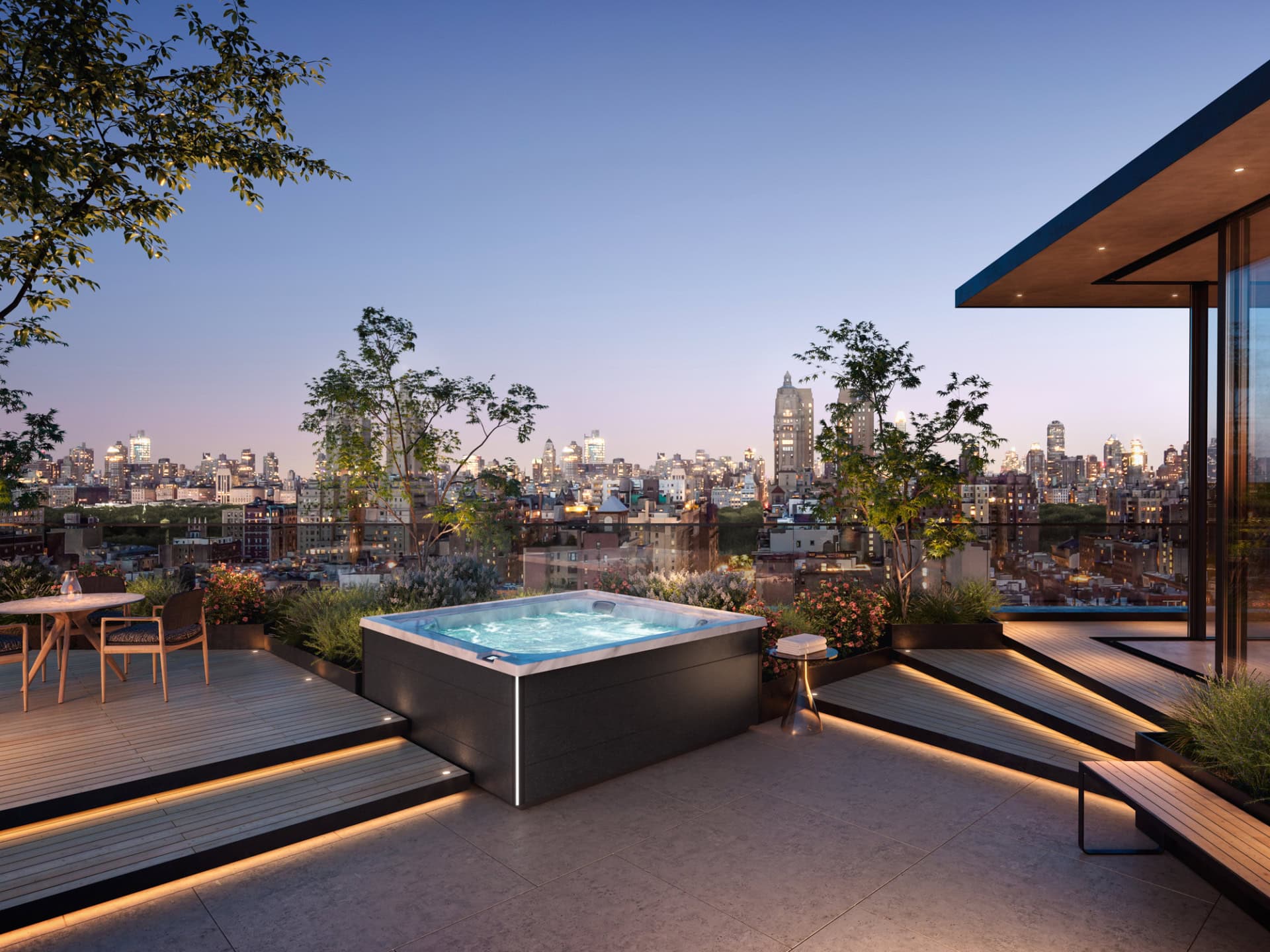 Dakterras met jacuzzi en stadzicht bij zonsondergang.
