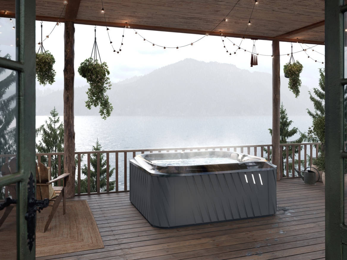 Bubbelbad op houten terras met uitzicht op meer.