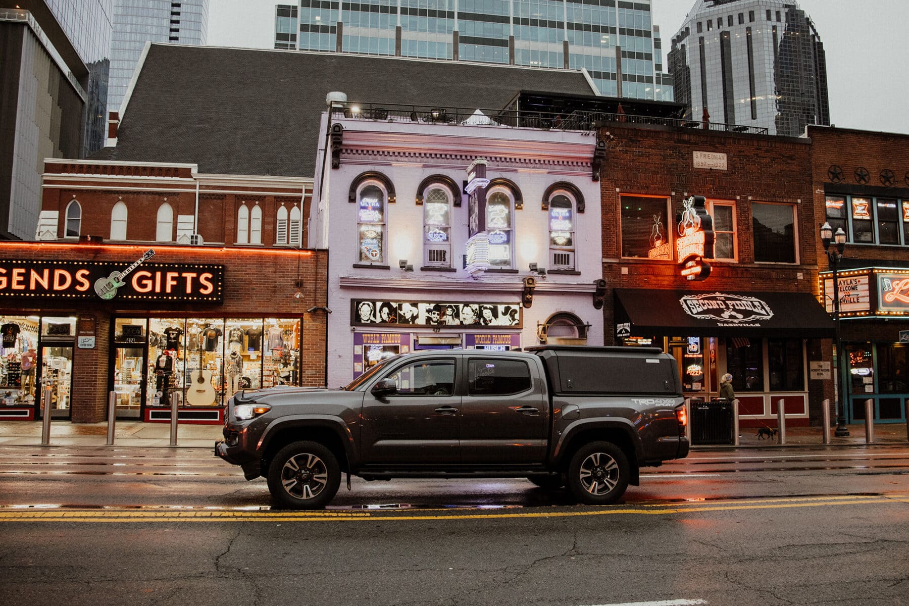 Stainless steel truck cap mounted on a pickup truck parked on a city street, showcasing durable and non-modular truck bed cover for commercial and recreational use.
