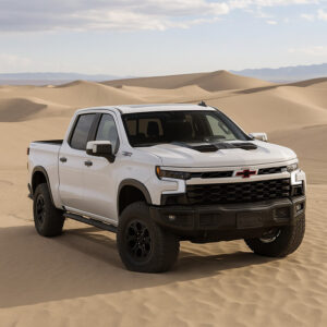Stainless steel truck cap mounted on a white pickup truck in a desert landscape.
