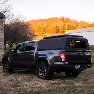 Stainless steel non-modular truck cap installed on a Toyota Tacoma pickup truck, providing durable bed coverage and security.