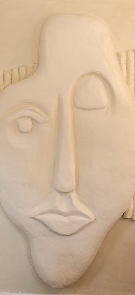 Elegant abstract face sculpture, minimalist design, cream-colored material, contemporary wall art decor, aesthetic interior decoration, ART OF DENTISTRY focus, stylish home or office accessory.